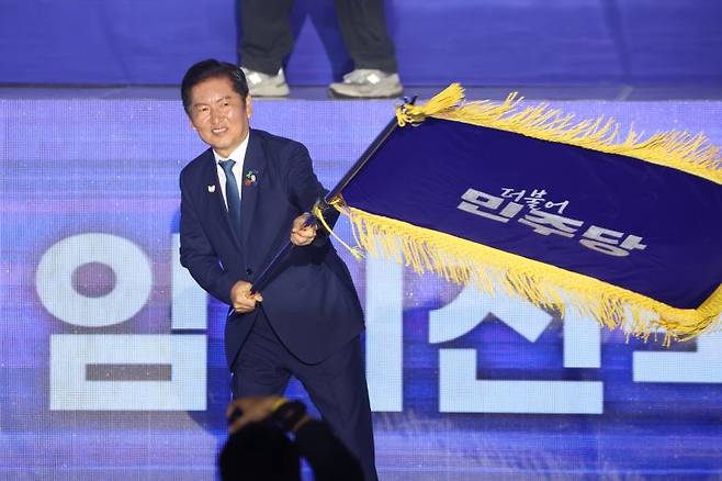 더불어민주당 정청래 신임 당대표가 2일 고양 킨텍스에서 열린 전국당원대회에서 김병기 당대표 직무대행 겸 원내대표로부터 받은 당기를 흔들고 있다. 사진=연합뉴스