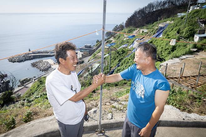 석리 마을 이장 이미상 씨(왼쪽)와 노인회장 김영기 씨가 손을 맞잡고 환하게 웃고 있다. 마을로 돌아온 이들은 일상 회복을 위해 바쁜 시간을 보내고 있다. 전민규 기자