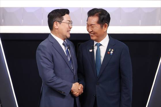 더불어민주당 대표 선거에 출마한 정청래(오른쪽)ㆍ박찬대 후보가 7월 27일 오후 서울 영등포구 여의도 KBS 신관 공개홀에서 2차 텔레비전 토론회 시작 전 악수하고 있다. 국회사진기자단