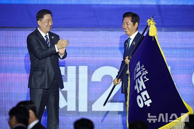 [고양=뉴시스] 고승민 기자 = 정청래 더불어민주당 신임 당대표가 2일 경기 고양시 킨텍스에서 열린 제2차 임시전국당원대회에서 김병기 원내대표로 부터 당기를 이양받고 있다. (공동취재) 2025.08.02. photo@newsis.com