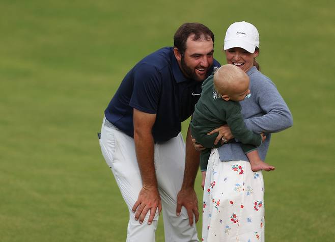 스코티 셰플러가 지난달 20일 제153회 디 오픈 챔피언십에서 우승한 뒤, 18번 홀 그린 위에서 아내 메러디스 셰플러, 아들 베넷과 함께 기쁨을 나누고 있다. 로이터