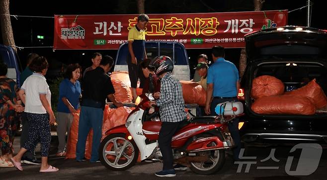 3일 새벽 문을 연 충북 괴산 '홍고추 직거래시장'에서 소비자가 품질을 살펴보며 흥정을 하고 있다.(괴산군 제공)/뉴스1