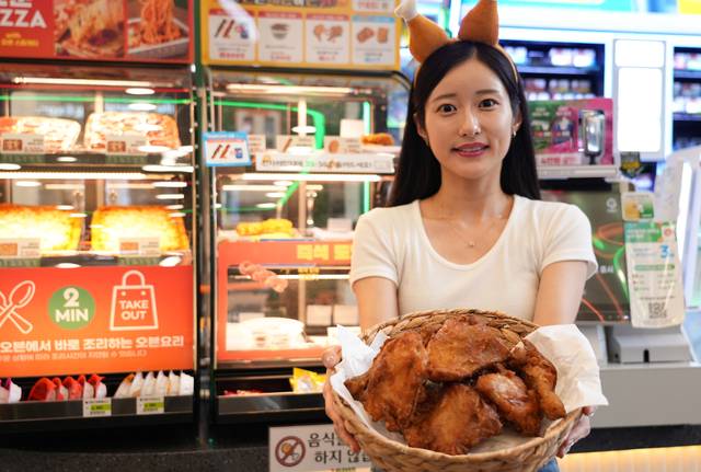 세븐일레븐 매장에서 모델이 ‘한도초과 옛날통닭’을 소개하고 있다. [세븐일레븐 제공]