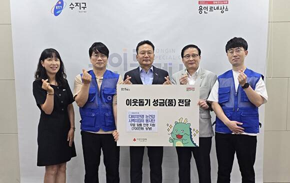 다비치안경 눈건강시력진킴이 봉사단 관계자들이 이영민 수지구청장(왼쪽 세번째)에게 성금을 전달한 후 기념 촬영을 하고 있다. [사진=용인특례시]