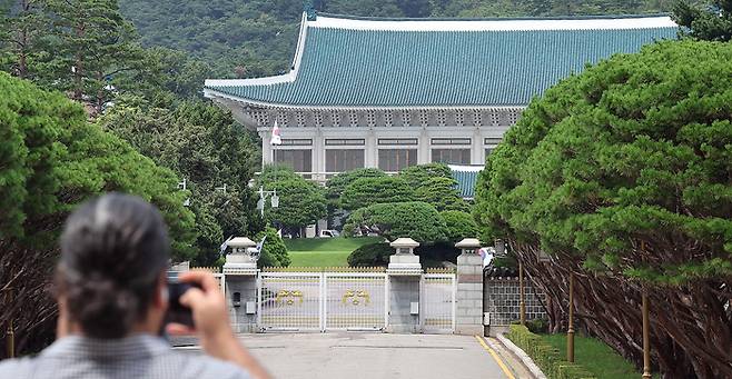 청와대 관람 일시 종료를 하루 앞둔 31일 오후 서울 종로구 청와대 정문 앞에서 한 관광객이 스마트폰으로 촬영하고 있다.  [뉴스1]