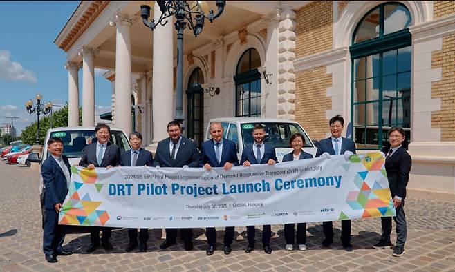 기획재정부 및 현대차 관계자, 헝가리 정부 관계자 등이 지난달 31일(현지시간) 헝가리 괴될뢰시에서 개최된 수요응답형 교통 시범사업 개통식에 참석해 기념촬영을 하고 있다. 기획재정부 제공