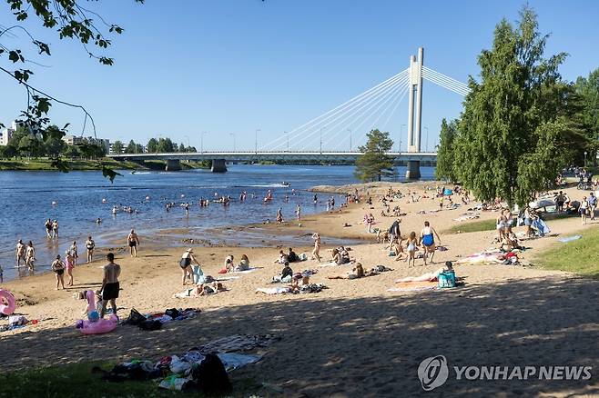 지난 7월 15일 핀란드 로바니에미의 케미 강가에서 시민들이 더위를 피해 물놀이를 즐기고 있다.[로이터=연합뉴스. 재판매 및 DB 금지]