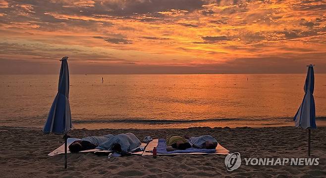 백사장에서 동틀 때까지 꿀잠 (강릉=연합뉴스) 유형재 기자 = 강원 강릉지역의 밤 최저기온이 28.2도를 기록하며 지난달 20일부터 14일째 열대야가 이어진 3일 경포해수욕장 백사장에서 피서객들이 잠을 자고 있다. 2025.8.3 yoo21@yna.co.kr