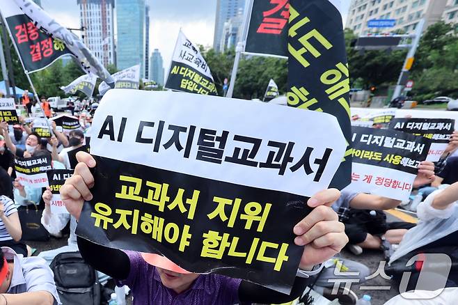 한국교과서협회 회원들이 지난달 21일 오전 서울 영등포구 여의도 국회의사당역 앞에서 열린 초·중등교육법 개정안 규탄 집회에서 AI 디지털교과서(AIDT)의 '교과서' 지위 유지를 촉구하고 있다. 2025.7.21/뉴스1 ⓒ News1 황기선 기자