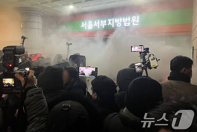19일 새벽 윤석열 당시 대통령에 대한 구속영장이 발부되자 서울 서부지법에 지지자들이 진입해 소화기를 뿌리며 난동을 부리고 있다. 이 사진 역시 만약 법원 울타리 바깥에서 있었다면 촬영해지 못했을 것이다. 2025.1.19/뉴스1 ⓒ News1 김민수 기자