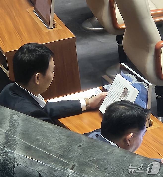 신동욱 국민의힘 의원이 4일 서울 여의도 국회에서 열린 제427회 국회(임시회) 3차 본회의에 상정된 방송법 일부개정법률안(대안)에 대한 무제한 토론(필리버스터)을 하고 있는 가운데 김용민 더불어민주당 의원이 책을 보고 있다. 2025.8.4/뉴스1 ⓒ News1 박기현 기자