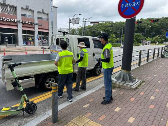 천안시 공무원들이 도로에 무단 방치된 PM을 견인하고 있다. 천안시 제공