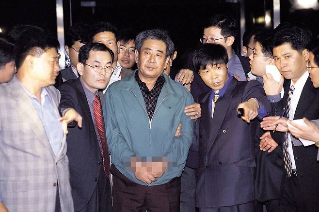 김근태 민청련(민주화운동청년연합) 의장을 고문했던 공안 경찰 이근안(가운데)씨가 1999년 10월 검찰에 송치되고 있다. 1988년부터 11년 가까이 도망 다니다 자수한 이씨는 7년의 실형을 살고 나온 뒤 목사로 변신했다. 한겨레 자료사진