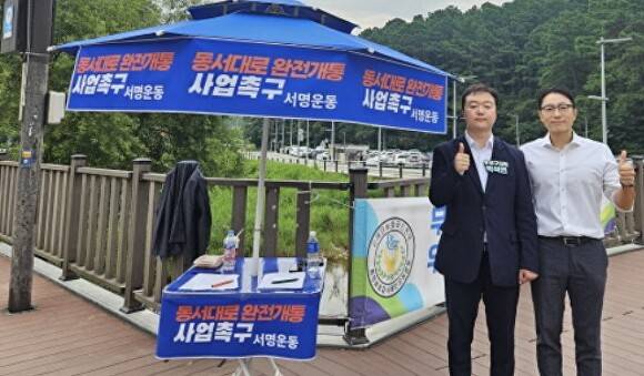 박석연 유성구의원(사진 왼쪽)이 3일 동서대로의 완전한 개통을 촉구하는 서명운동을 벌이고 있다.  [사진=박석연의원실]