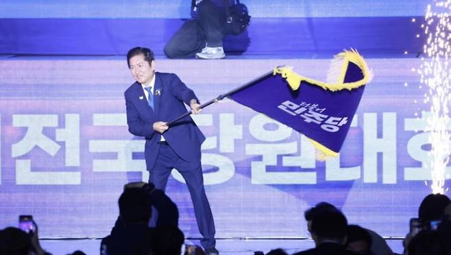 정청래 더불어민주당 신임 당대표가 2일 열린 제2차 임시전국당원대회에서 당기를 흔들고 있다. (SNS 캡처)
