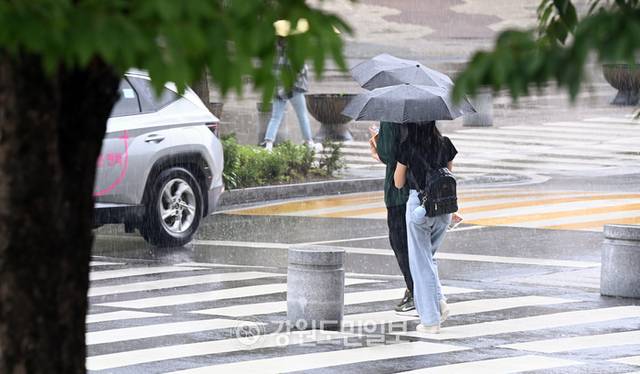 ▲ 강원대 춘천캠퍼스에서 학생들이 소나기를 피해 우산을 쓰고 강의실로 가고 있다. 방도겸 기자