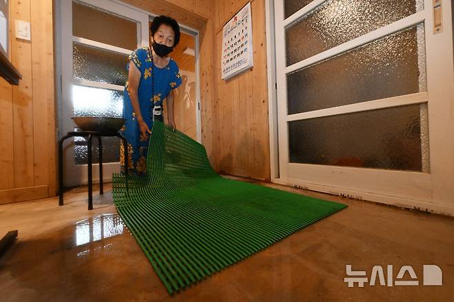 [광주=뉴시스] 이영주 기자 = 4일 오전 광주 북구 신안동 주민 백정자(86·여)씨가 전날 쏟아진 197.5㎜ 폭우에 침수된 집 침실에서 허망한 표정으로 빗물이 고였던 흔적을 가리키고 있다. 백씨는 지난달 17일 광주지역에 426㎜ 폭우가 쏟아졌을 당시에도 침수 피해를 입었다. 2025.08.04. leeyj2578@newsis.com