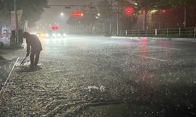 지난 3일 호우경보가 발효 중인 광주시 광산구 운남동 도로에서 한 공무원이 하수관로를 정비하고 있다. 뉴스1