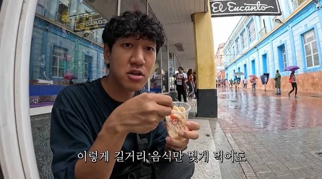 여행 유튜버 상가의 쿠바 여행기 한 장면. 상가가 한국 돈으로 200원가량 하는 샐러드 형태의 길거리 음식을 먹고 있다. 유튜브 채널 ‘상가의 안녕히살아보기’ 캡처