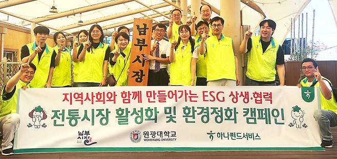 지난 1일 전북특별자치도 익산시 남부시장에서 진행된 '전통시장 활성화 및 환경정화 캠페인'에 참여한 김덕순 대표이사(앞줄 왼쪽 다섯번째)가 임직원들과 기념촬영을 하고 있다.