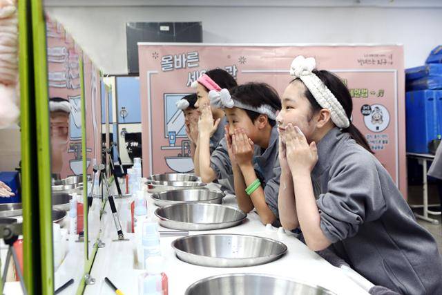 LG생활건강이 1월 서울 양천구 신남중학교에서 연 ‘빌려쓰는 지구스쿨’에 참석한 학생들이 세안 수업을 받고 있다. LG생활건강 제공