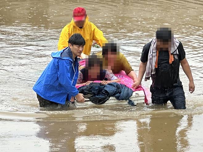지난달 19일 경남 합천군 삼가면의 한 마을에서 삼가면사무소 공무원과 마을의 젊은 주민, 청년회 회원들이 폭우에 고립된 주민을 구조하는 모습  (자료:합천군)