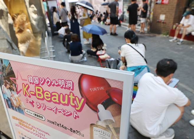 Visitors wait for a shop in Myeong-dong, central Seoul, to open on Aug. 1. [YONHAP]