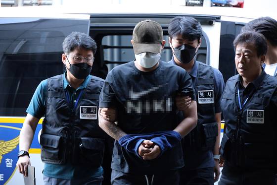A man in his 20s accused of murdering his ex-girlfriend in Daejeon enters the Daejeon Seobu Police Station on Aug. 5. [YONHAP]