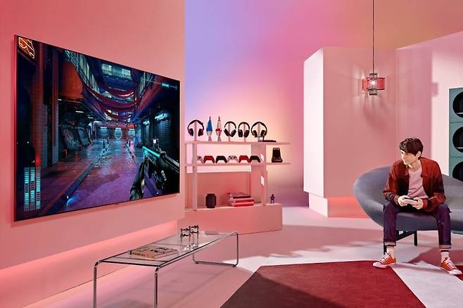 LG전자 모델이 LG QNED TV로 게임을 즐기고 있는 모습. [사진출처 = LG전자]