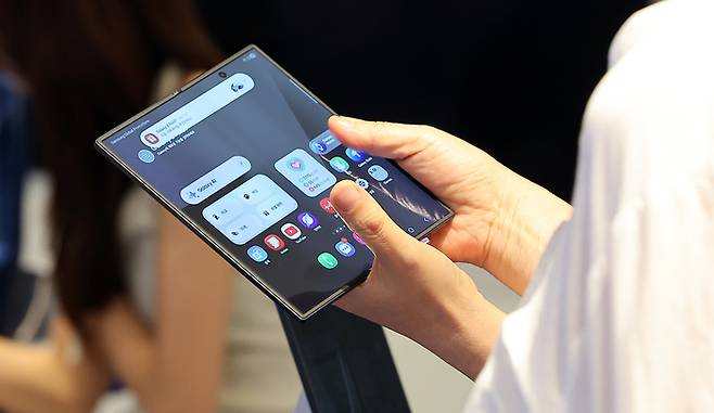 서울 영등포구 여의도 더현대 서울에 마련된 갤럭시 스튜디오에서 한 시민이 진열된 갤럭시Z폴드7을 살펴보고 있다. [사진 = 뉴스1]