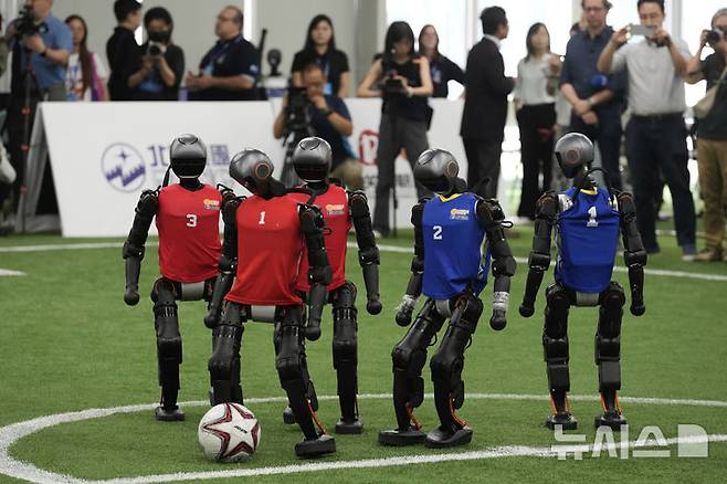 [베이징=AP/뉴시스] 4일(현지 시간) 중국 베이징에서 '2025 세계 휴머노이드 로봇 게임'을 앞두고 언론 공개 행사가 열린 가운데 부스터 휴머노이드 로봇들이 축구 시범 경기로 기술을 선보이고 있다. 오는 14일부터 17일까지 열리는 이 행사에는 축구를 비롯해 달리기, 격투, 댄스 등 실제 사람의 경기와 유사한 종목이 포함된 것으로 알려졌다. 2025.08.05.