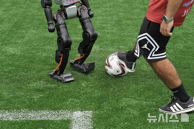 [베이징=AP/뉴시스] 4일(현지 시간) 중국 베이징에서 열리는 '2025 세계 휴머노이드 로봇 게임'을 앞두고 언론 공개 행사가 열린 가운데 부스터 휴머노이드 로봇들이 축구 시범 경기로 기술을 선보이고 있다. 오는 14일부터 17일까지 열리는 이 행사에는 축구를 비롯해 달리기, 격투, 댄스 등 실제 사람의 경기와 유사한 종목이 포함된 것으로 알려졌다. 2025.08.04.