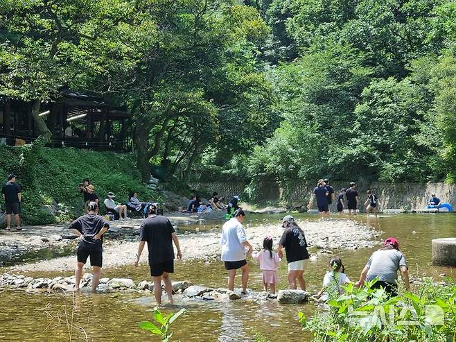[양주=뉴시스] 김도희 기자 = 5일 낮 12시께 경기 양주시 장흥계곡을 찾은 시민들이 무더위 속 그늘 아래에서 휴식을 취하거나 아이들과 함께 물놀이를 즐기고 있다. 2025.08.05 kdh@newsis.com