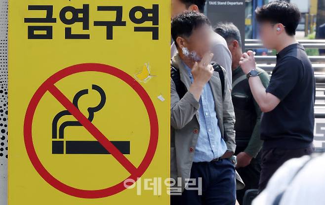 세계 금연의 날을 이틀 앞둔 지난 5월 29일 서울역광장 금연구역 표지판 옆에서 시민들이 담배를 피고 있다.(사진=뉴스1)