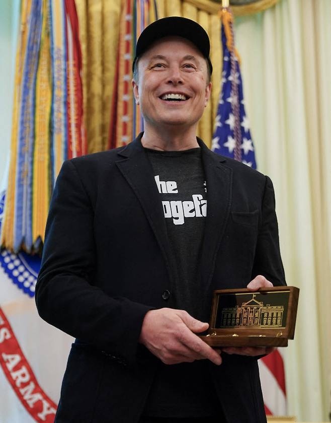 일론 머스크 테슬라 최고경영자(CEO)가 5월 30일 백악관에서 열린 고별식에서 백악관에 언제든지 돌아오라는 의미의 ‘황금 열쇠’를 받고 미소 짓고 있다. (사진 = AFP)