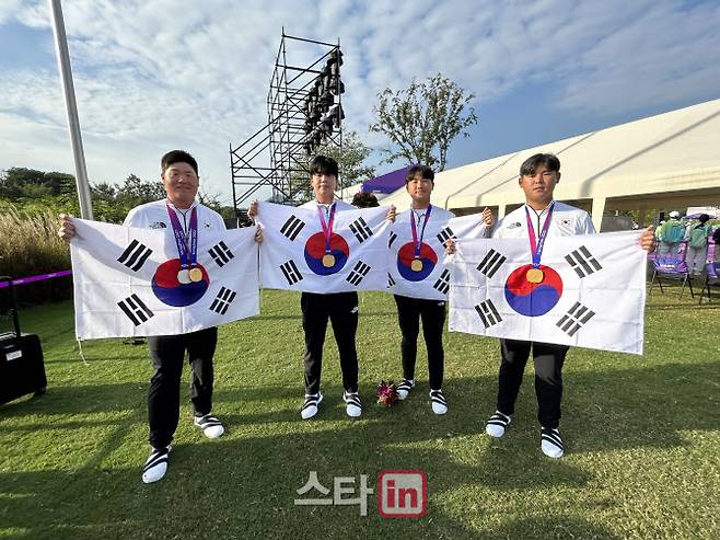 2022 항저우 아시안게임 남자 골프 단체전에서 금메달을 획득한 국가대표팀 선수들이 시상식 뒤 태극기를 펼쳐 보이며 기념촬영하고 있다. 왼쪽부터 임성재, 장유빈, 조우영, 김시우. (사진=KGA)