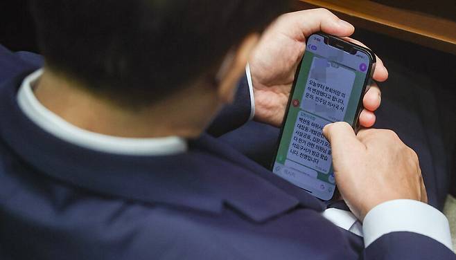 2022년 9월1일 이재명 더불어민주당 대표가 서울 여의도 국회에서 열린 본회의에서 김현지 보좌관(전 경기도청 비서관)에게 “백현동 허위사실공표, 대장동 개발관련 허위사실공표, 김문기 모른다 한거 관련 의원님 출석요구서가 방금 왔습니다. 전쟁입니다”라는 문자를 받고 있다. 공동취재사진