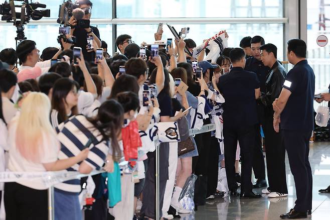 공항을 찾은 팬들에게 사인해주는 손흥민. [뉴스1]