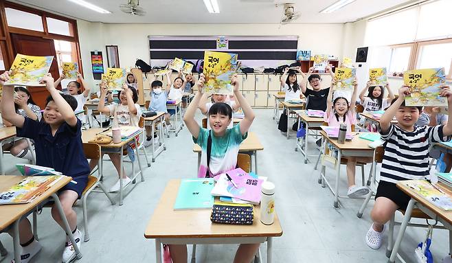 5일 여름방학을 마치고 개학한 경기도 수원시 영통구 잠원초등학교 4학년 교실에서 학생들이 환하게 웃으며 2학기 교과서를 보여주고 있다. 연합뉴스