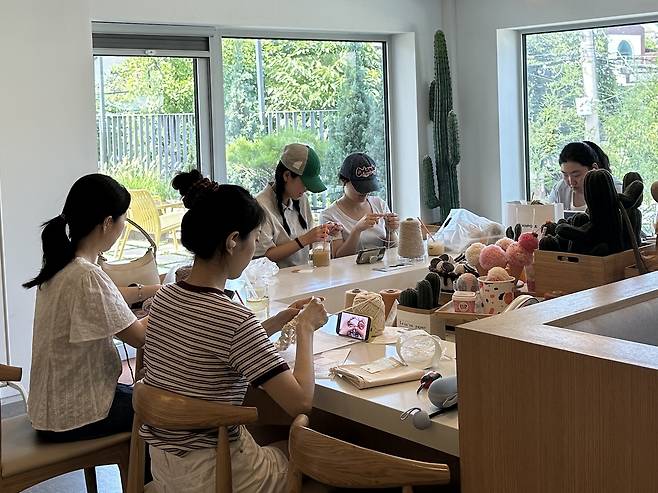 People knit together at Banul Story, a knitting shop and cafe located in Seodaemun-gu, western Seoul. (Lee Jung-joo/The Korea Herald)