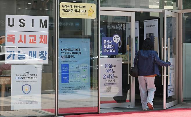 A customer enters a SK Telecom dealership in Seoul on June 23. [YONHAP]