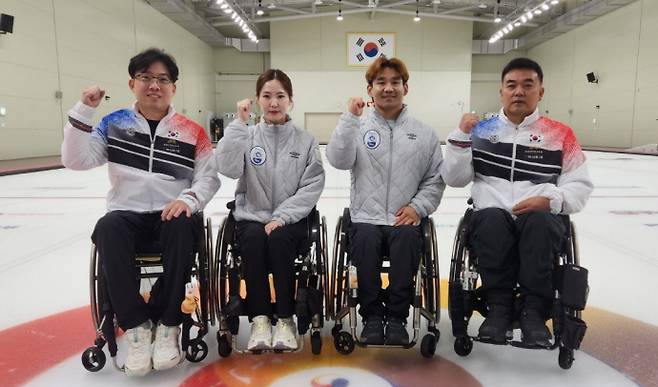 제14회 동계 패럴림픽 국가대표에 선발된 경기도 장애인체육회 휠체어컬링팀의 남봉광(사진 왼쪽부터), 백혜진, 이용석, 차진호가 파이팅을 외치며 사진을 찍고 있다. 사진=경기도장애인체육회