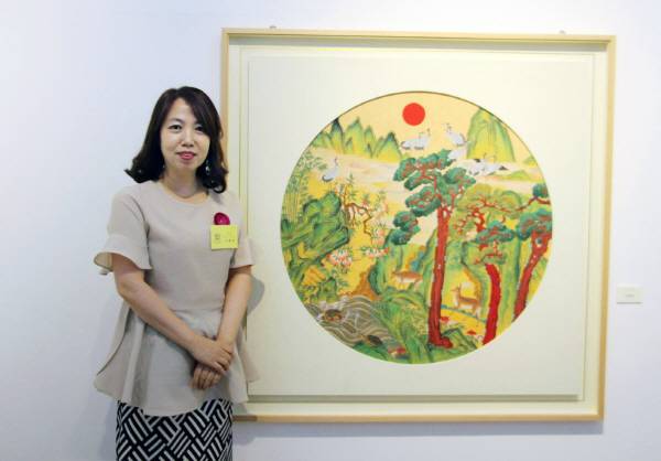 이종임 작가가 봉산문화회관에서 열린 (사)한국현대민화협회 회원전에 참여해 자신의 작품인 '장생도' 앞에 서 있다.