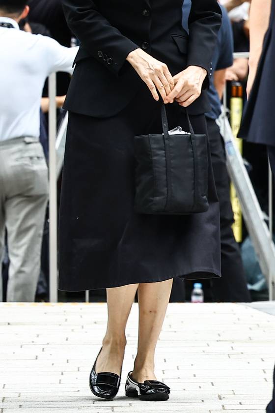 김건희 여사가 6일 오전 김건희 특검팀 사무실에 피의자 신분으로 출석하면서 14만원대 검은색 에코백을 들고 있다.. 김종호 기자