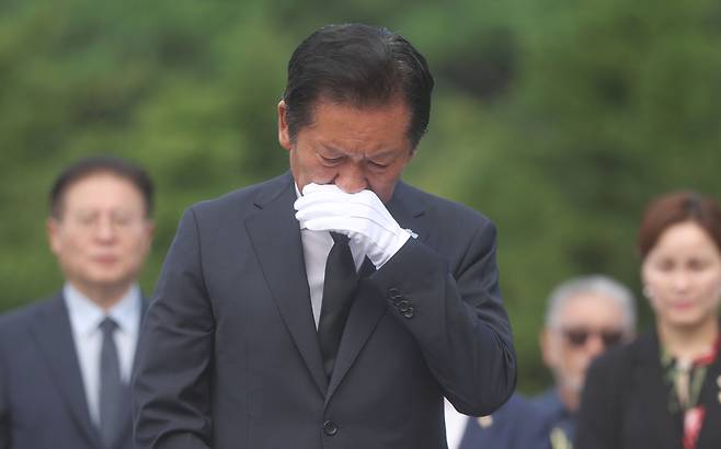 정청래 더불어민주당 대표가 7일 경남 김해시 진영읍 봉하마을을 방문해 노무현 전 대통령 묘역을 참배한 후 손으로 얼굴을 닦고 있다. 연합뉴스