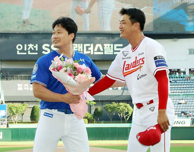 [서울=뉴시스] 프로야구 SSG 랜더스 김광현(오른쪽)이 7일 인천 SSG랜더스필드에서 열린 2025 신한 쏠뱅크 KBO리그 삼성 라이온즈와의 경기에 앞서 오승환에게 꽃다발을 전달했다. (사진=SSG 랜더스 제공) 2025.08.07. *재판매 및 DB 금지