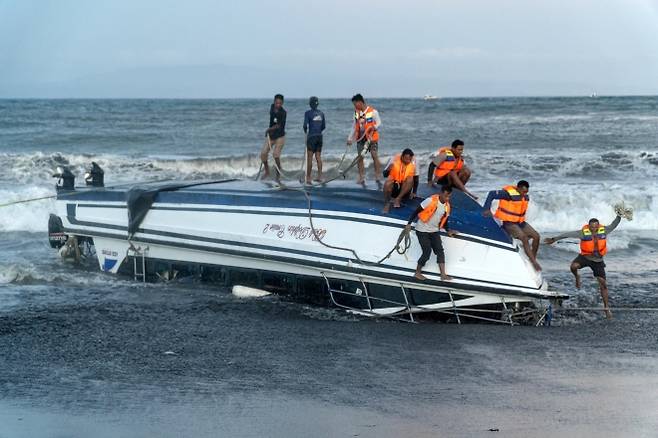 5일(현지시간) 인도네시아 발리 사누르 해변에서 전복된 쾌속정을 현지 구조대와 사람들이 해안으로 끌어올리고 있다. 이 사고로 중국인 관광객 2명과 현지인 승무원 1명이 사망했다. 2025.8.5 신화 연합뉴스