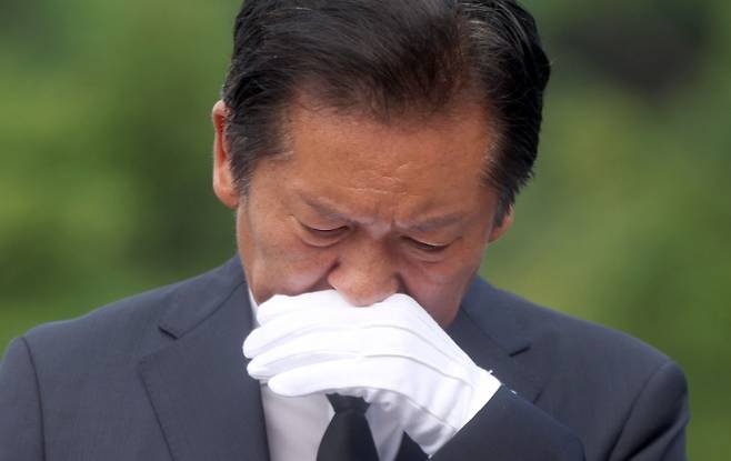 정청래 더불어민주당 대표가 7일 오전 경남 김해시 진영읍 봉하마을을 방문해 노무현 전 대통령 묘역을 참배 후 손으로 얼굴을 닦고 있다. 2025.8.7 연합뉴스
