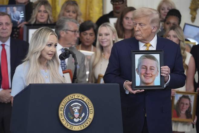 도널드 트럼프 미국 대통령이 지난 7월 16일 백악관에서 열린 '펜타닐의 치명적인 밀매를 모두 중단하라'는 이름의 법안 서명식에서 펜타닐로 목숨을 잃은 청소년의 사진을 들고 그의 어머니가 연설하는 모습을 보고 지켜보고 있다. 이날 트럼프 대통령은 "중국에서 펜타닐을 만들어 우리나라로 보내는 사람에게 사형이 집행될 것"이라고 말했다. 펜타닐과 관련해 중국에 20%의 관세를 부과한 데 대해 "징벌(penalty)"이라고 언급했다. [AP=연합뉴스]