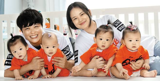 지난 1일 오후 정재룡(왼쪽)·가미소 부부가 네쌍둥이 남매를 안고서 활짝 웃고 있는 모습. 앞줄 맨 왼쪽부터 첫째 서하, 둘째 시하, 셋째 도하, 넷째 율하. 야구장에서 처음 만나 결혼을 하게 된 두 사람은 "아이가 한 번에 네 명이 생겼다. 만루 홈런을 친 것"이라고 했다. /신현종 기자